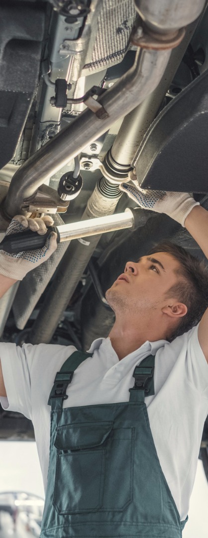 Mechanic Using Light To Check Underneath Car For Repairs