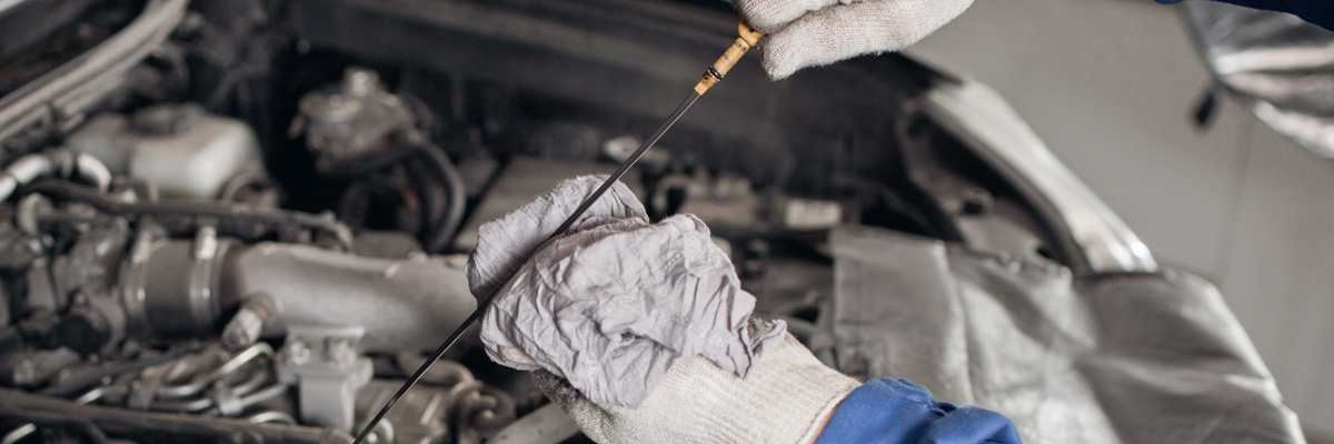 Mechanic Checking Oil In Car Engine - Wiping Oil From Dipstick