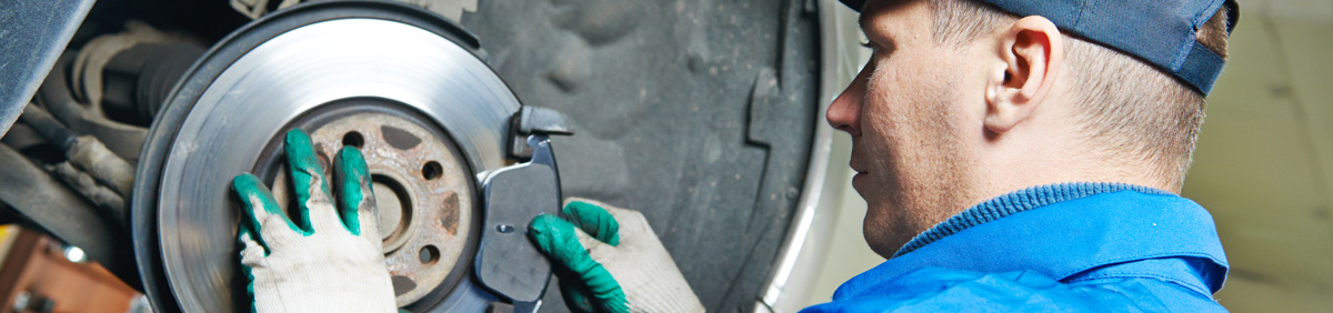 Mechanic Performing Repairs To Car Wheel